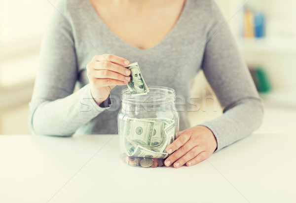 close up of woman hands and dollar money in jar Stock photo © dolgachov