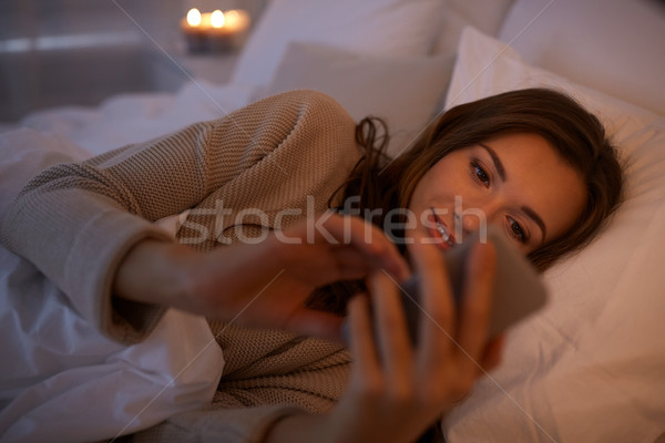 Stockfoto: Jonge · vrouw · smartphone · bed · home · slaapkamer · technologie