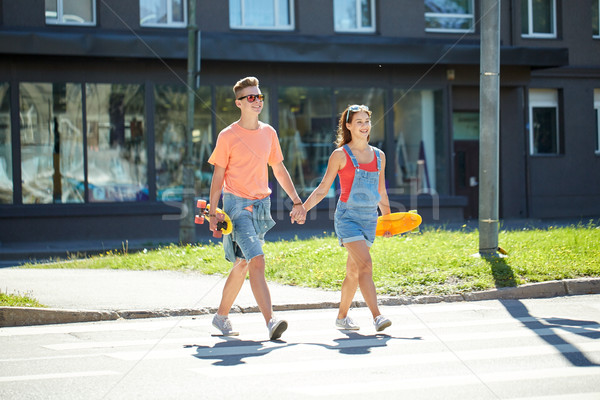 teenage couple with skateboards on city street Stock photo © dolgachov