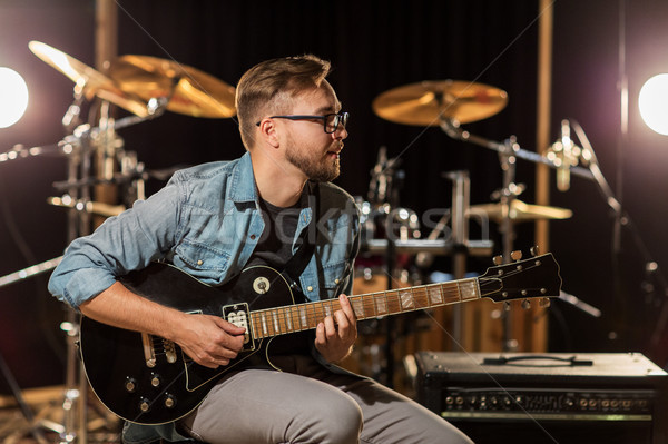 man playing guitar at studio rehearsal Stock photo © dolgachov