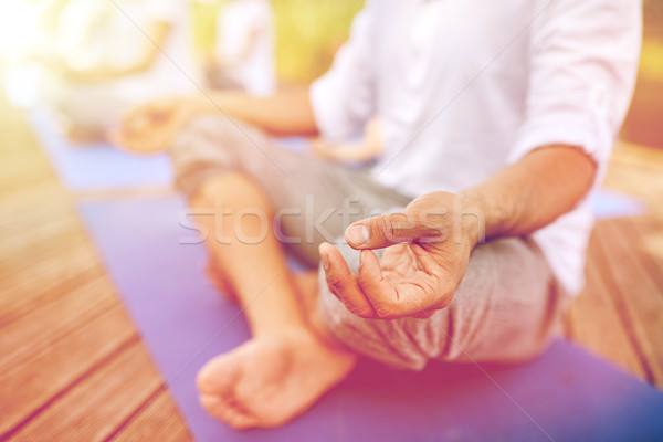close up of people making yoga exercises outdoors Stock photo © dolgachov