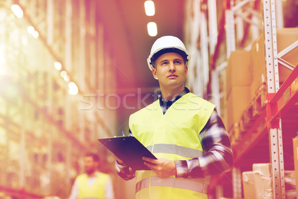 Stock photo: man with clipboard in safety vest at warehouse