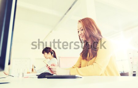 businesswoman texting on smartphone at office Stock photo © dolgachov