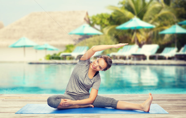 happy woman making yoga and stretching on mat Stock photo © dolgachov