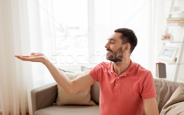 happy man holding something imaginary at home Stock photo © dolgachov