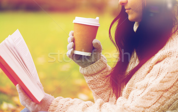woman with book drinking coffee in autumn park Stock photo © dolgachov
