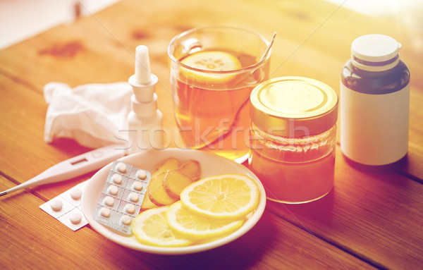 drugs, thermometer, honey and cup of tea on wood Stock photo © dolgachov