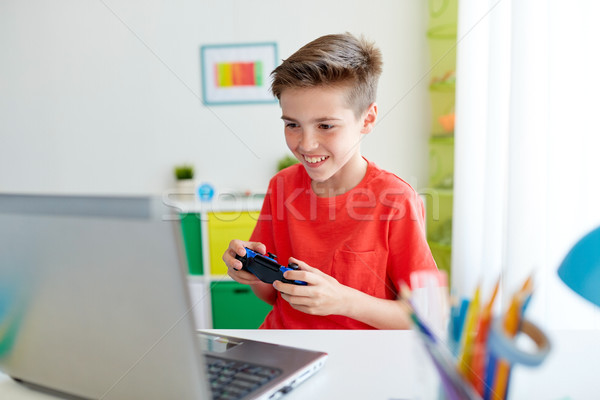 男孩 手柄 播放 視頻遊戲 筆記本電腦 商業照片 © dolgachov