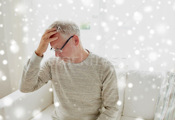 senior man suffering from headache at home Stock photo © dolgachov