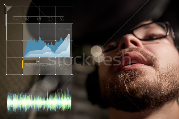 man with headphones singing at recording studio Stock photo © dolgachov