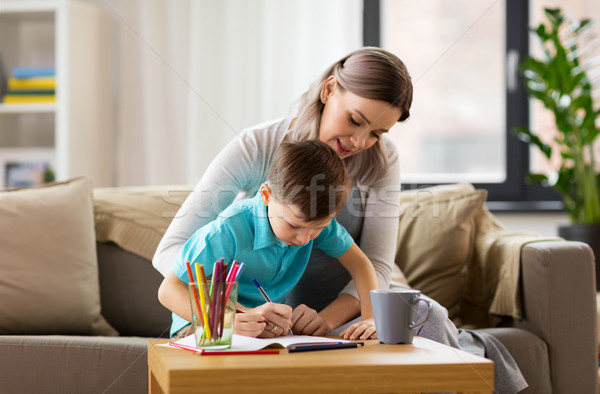 mother and son with workbook at home Stock photo © dolgachov