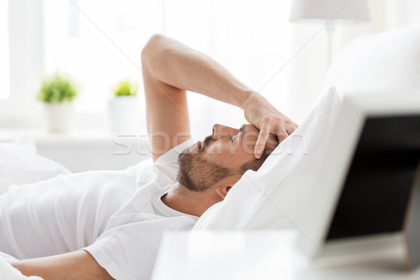 Om pat acasă durere de cap oameni Imagine de stoc © dolgachov