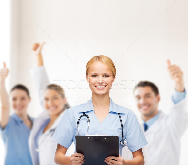 smiling female doctor or nurse with clipboard Stock photo © dolgachov