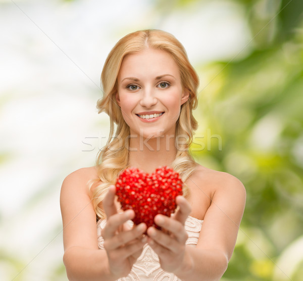 Stock photo: smiling woman giving small red heart