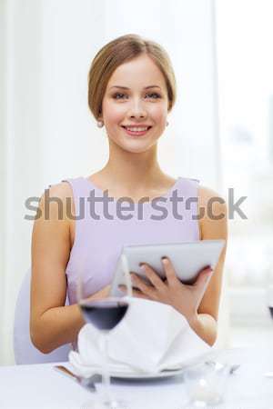 smiling woman with tablet pc computer at resturant Stock photo © dolgachov