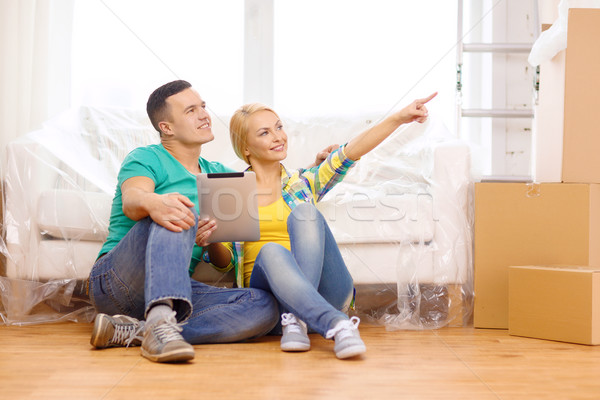 smiling couple with tablet pc in new home Stock photo © dolgachov