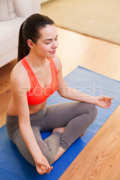 smiling teenager meditating at home Stock photo © dolgachov