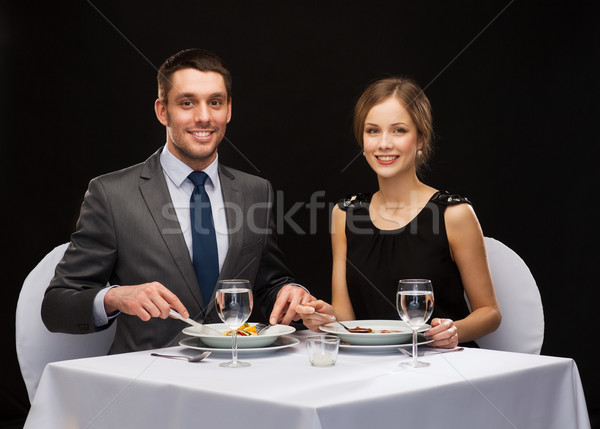 smiling couple eating main course at restaurant Stock photo © dolgachov
