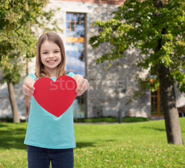 Stock photo: smiling little girl giving red heart