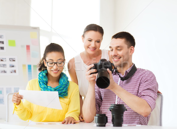 smiling team with photocamera working in office Stock photo © dolgachov