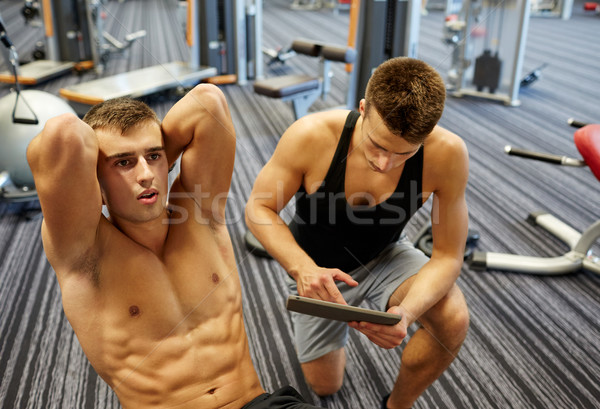 men flexing abdominal muscles in gym Stock photo © dolgachov