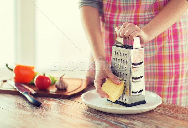 close up of female hands grating cheese Stock photo © dolgachov