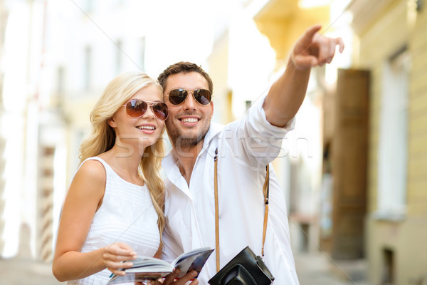 couple with map, camera and travellers guide Stock photo © dolgachov
