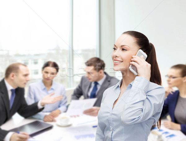 Jeunes souriant femme d'affaires smartphone affaires technologie [[stock_photo]] © dolgachov