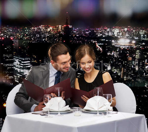 smiling couple with menus at restaurant Stock photo © dolgachov