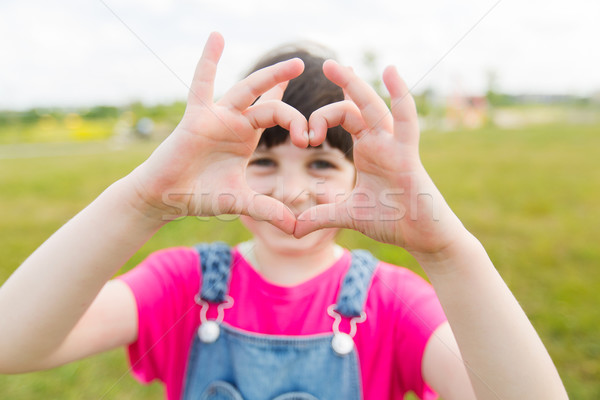 happy little girl making heart shape gesture Stock photo © dolgachov