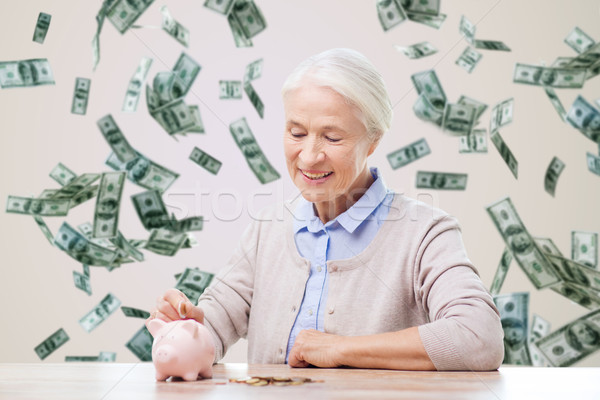 senior woman putting money to piggy bank at home Stock photo © dolgachov