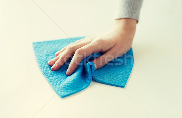 Stock photo: close up of hand cleaning table surface with cloth