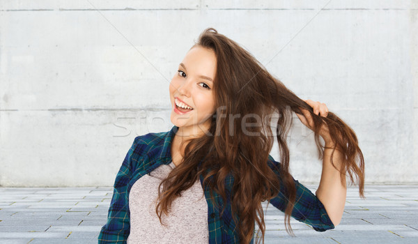 happy teenage girl holding strand of her hair Stock photo © dolgachov