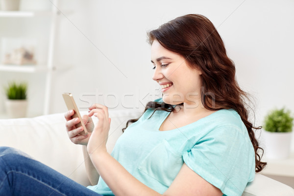Stock photo: happy plus size woman with smartphone at home