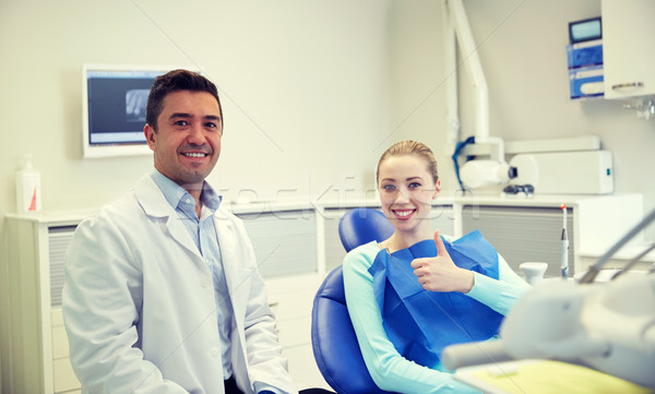 happy male dentist with woman patient at clinic Stock photo © dolgachov