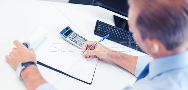 businessman with notebook and calculator Stock photo © dolgachov