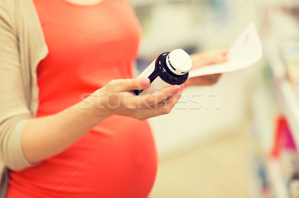 pregnant woman with medication jar at pharmacy Stock photo © dolgachov