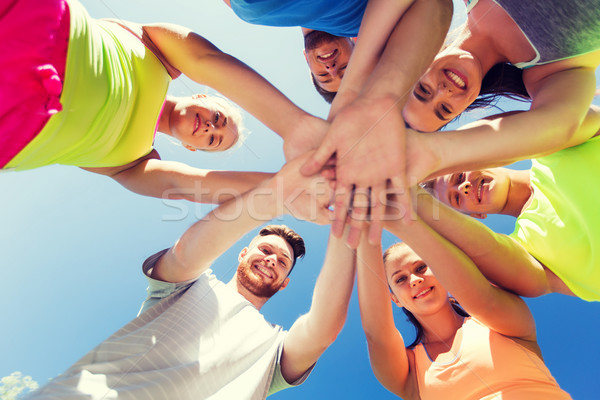 group of happy friends with hands on top outdoors Stock photo © dolgachov