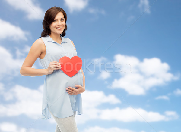 Feliz mulher grávida vermelho coração tocante barriga Foto stock © dolgachov