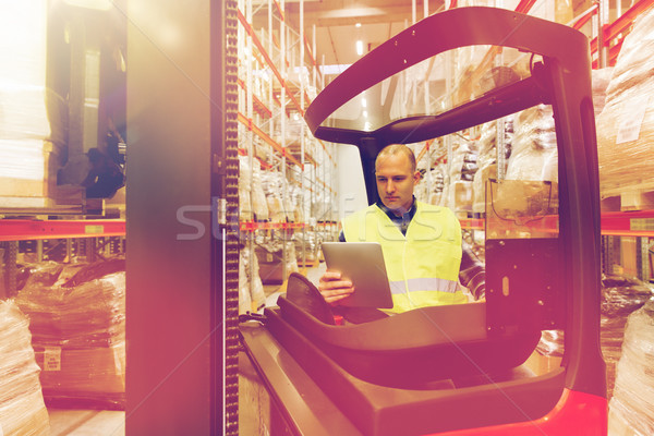 man with tablet pc operating forklift at warehouse Stock photo © dolgachov