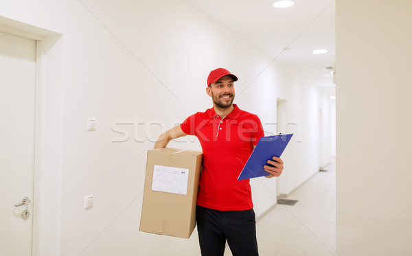 delivery man with box and clipboard in corridor Stock photo © dolgachov