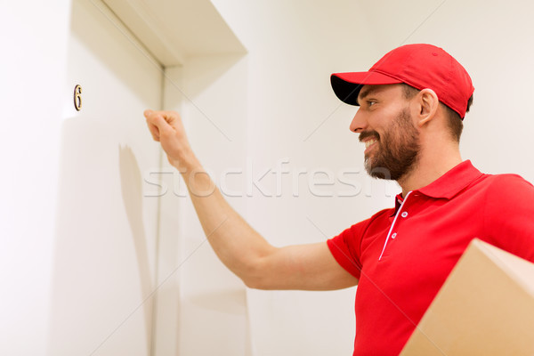 delivery man with parcel box knocking on door Stock photo © dolgachov
