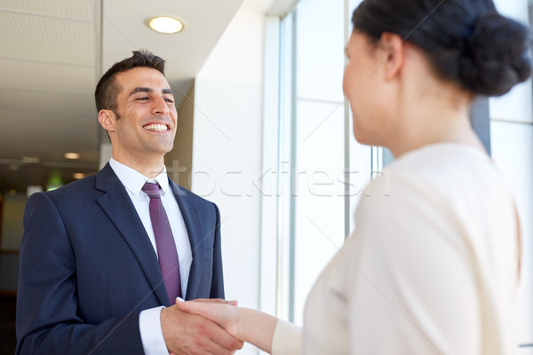 smiling business people shaking hands at office Stock photo © dolgachov