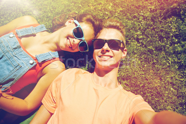 happy teenage couple taking selfie on summer grass Stock photo © dolgachov