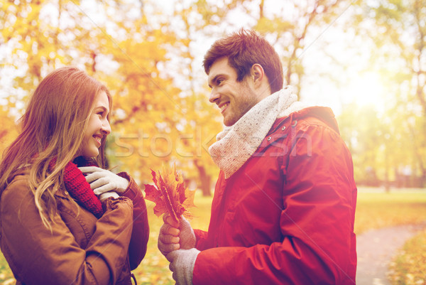 happy couple with maple leaves in autumn park Stock photo © dolgachov