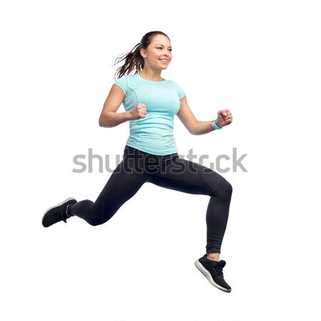 happy smiling sporty young woman jumping in air Stock photo © dolgachov