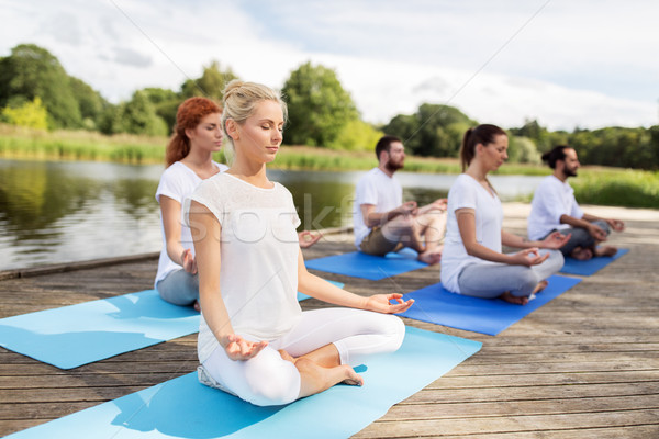 people meditating in yoga lotus pose outdoors Stock photo © dolgachov