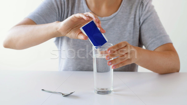 woman pouring medication into glass of water Stock photo © dolgachov
