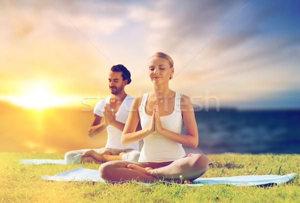 happy couple making yoga and meditating outdoors Stock photo © dolgachov