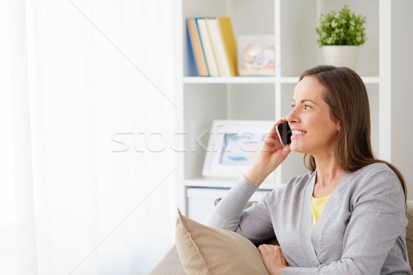 happy woman calling on smartphone at home Stock photo © dolgachov